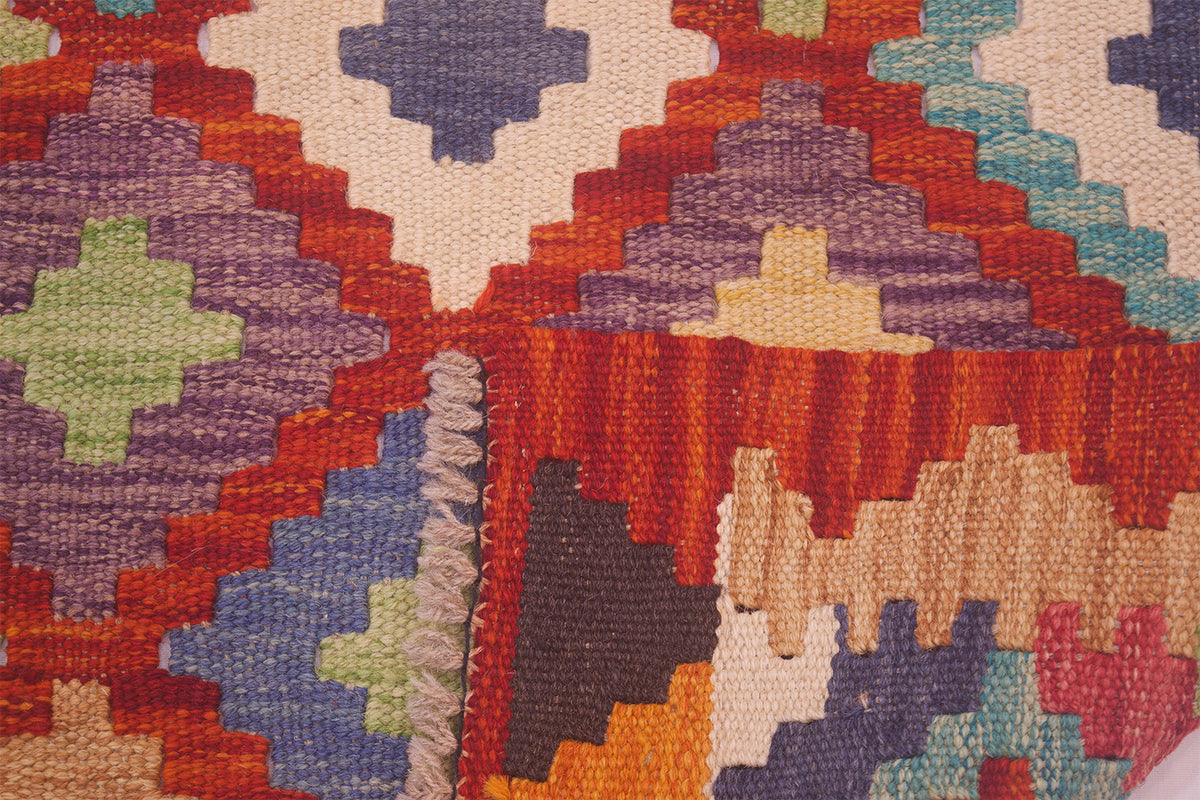 Kil im rug corner detail with multicolor geometric pattern and short fringe edge
