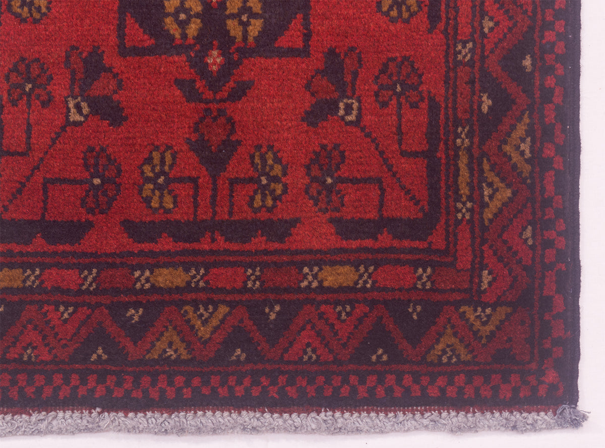 Red rug runner edge with border pattern and textured pile