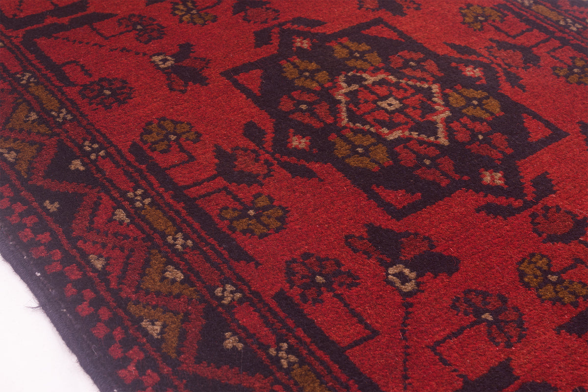 Close-up of red rug runner pattern with dark navy and gold details
