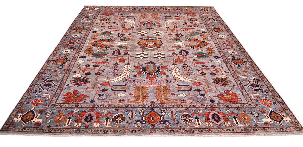 Over all view of Afghan Aryana Carpet inspired by Serapi design of bold combination of geometric and floral motifs with orange, ochre and lilac. The main field is grey with a blue background and Serapi cloud band design border.