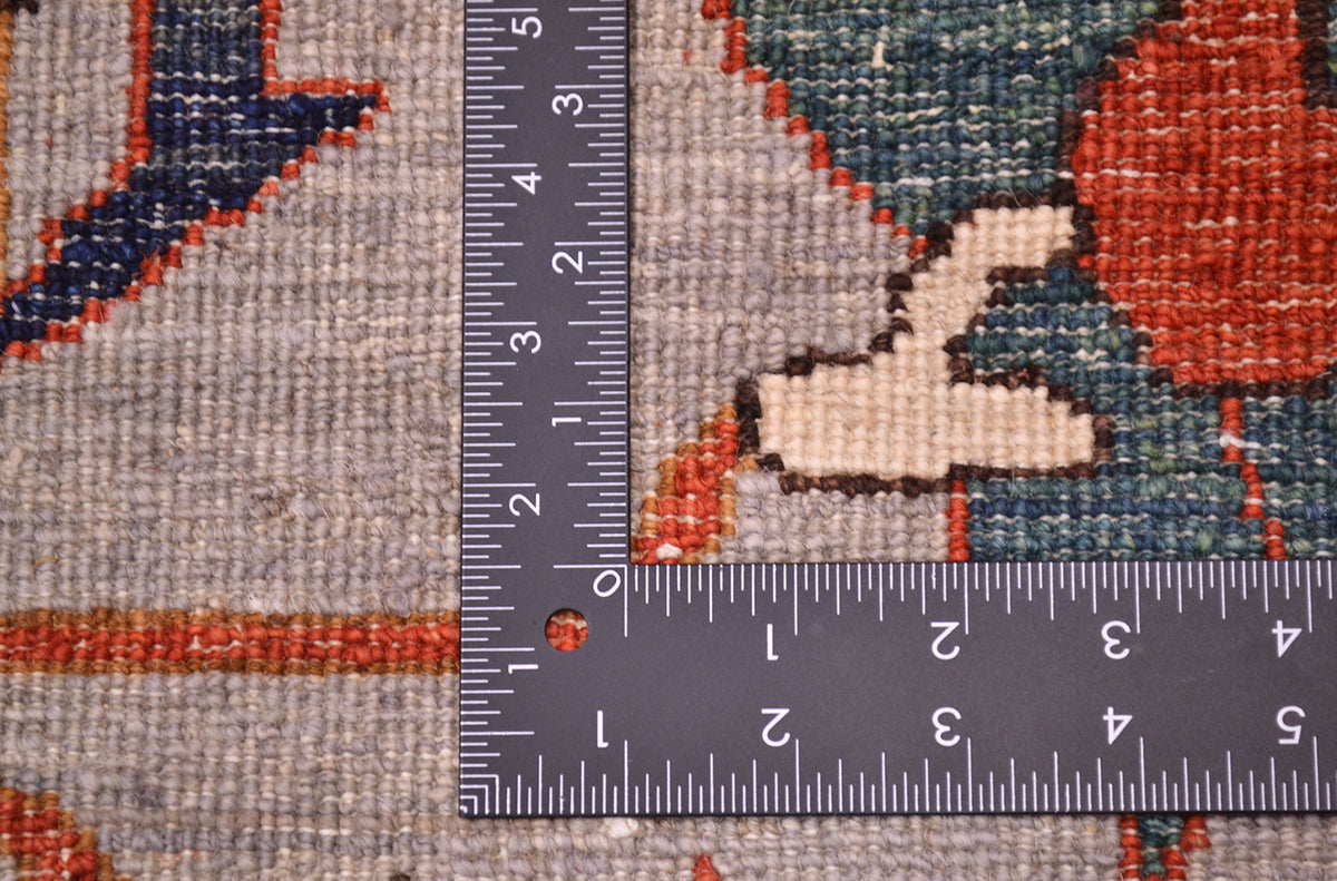 Reverse of handknotted carpet showing detail of knotting and natural vegetable dyed pure wool with teals, grey ands rust-orange.
