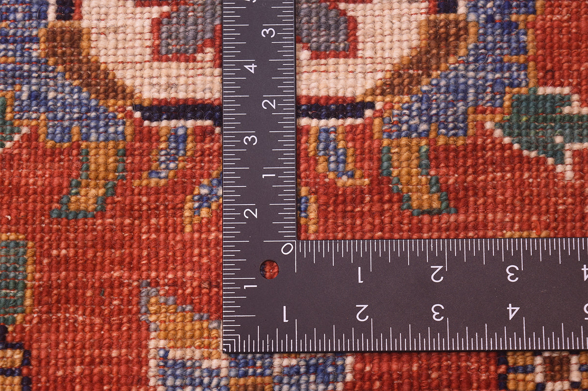 Handknotted Sultanabad design carpet weave close-up with ruler across red pattern