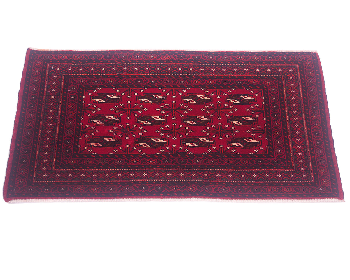 A rectangular Afghan Belouch-style mat with a deep red field, dark navy blue borders, and beige geometric motifs, shown flat against a white background.