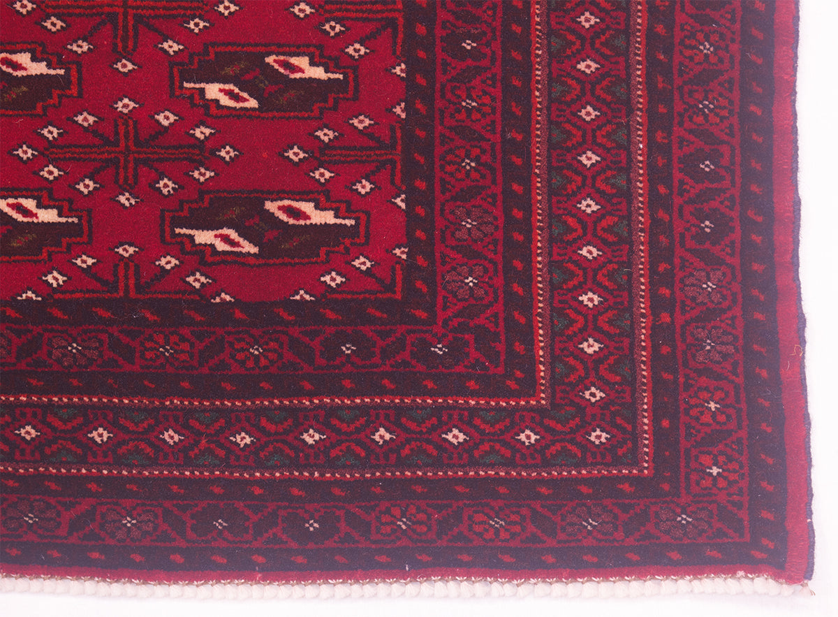 Corner of Afghan handmade red Belouch mat