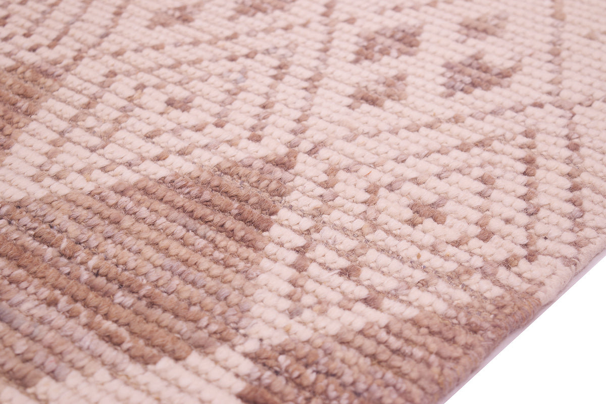A close-up of a textured woven rug/runner with a geometric diamond pattern in shades of beige, tan, and light brown.