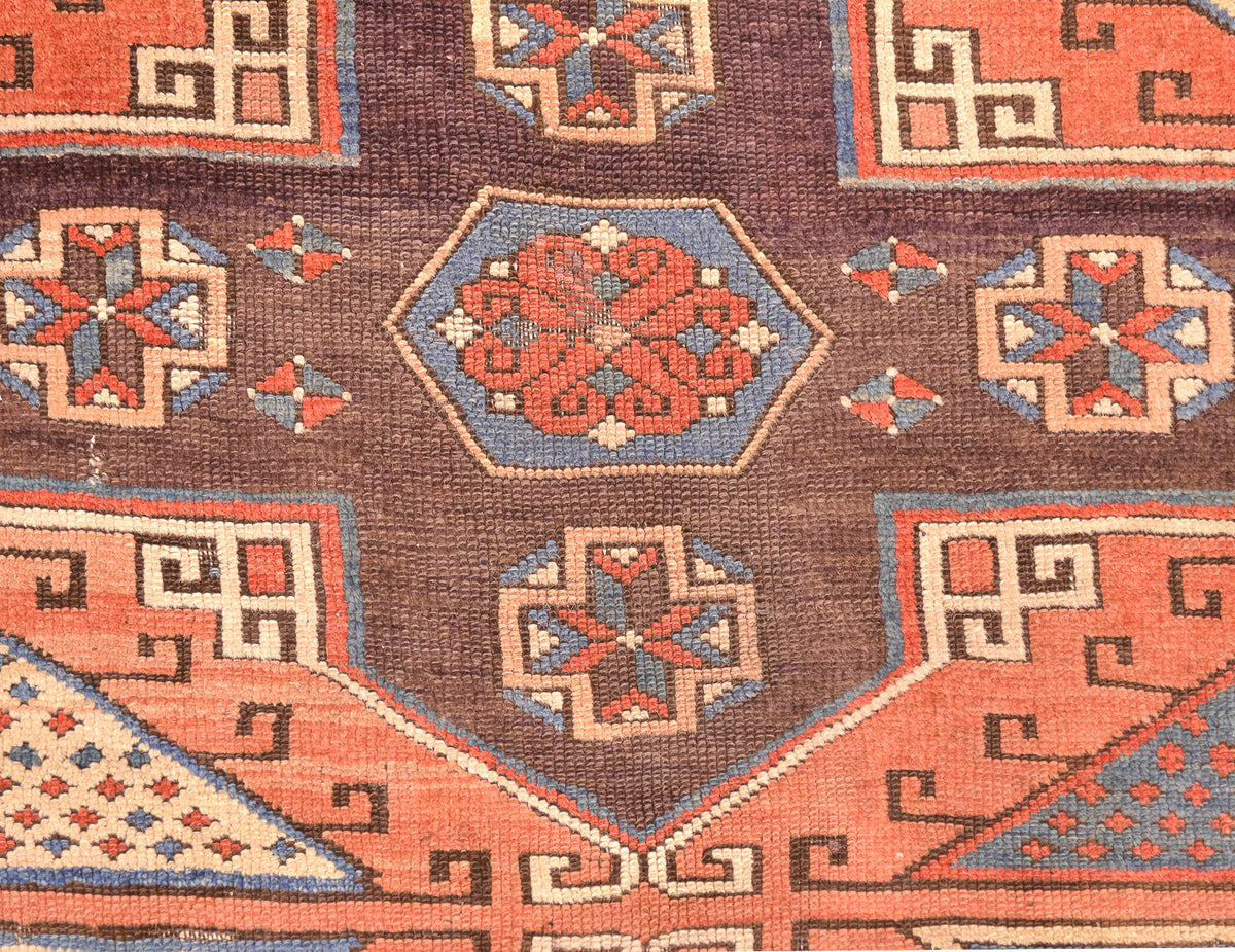 Close-up of Antique Bergama rug with rust hexagon medallion and repeating corner blocks