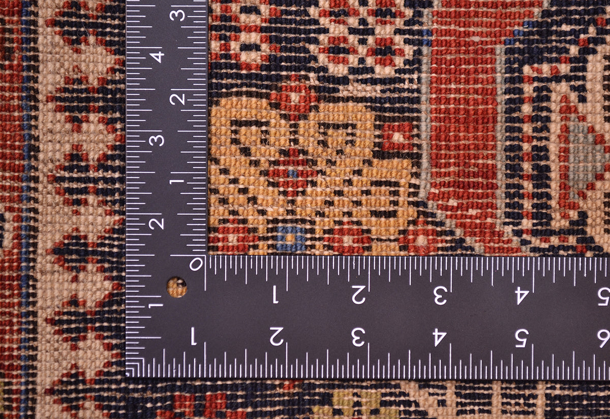 Antique Shirvan rug detail with geometric medallion in red, blue, cream, with ruler