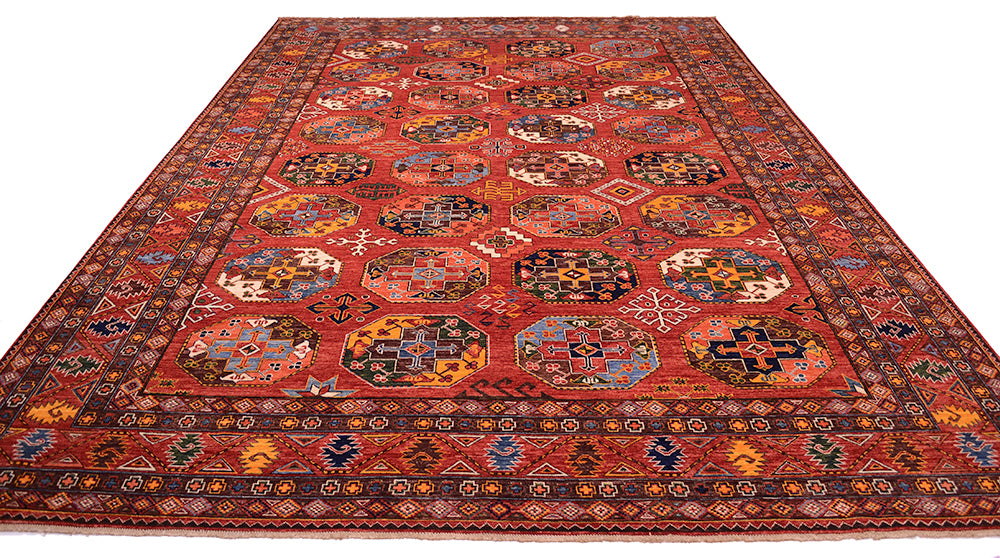A traditional large hand-knotted Ersari carpet with a rust field, featuring intricate geometric medallion motifs and a detailed border in shades of blue, yellow, black, and white.