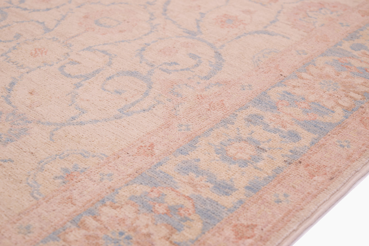 Detail of handmade runner with delicate colouring of pale cream, blue and pink terracotta detailing.