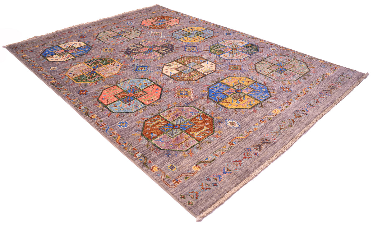 A rectangular handmade Afghan elephants foot design area rug with a muted grey background and multiple colourful geometric medallion motifs in blue, orange, beige, and brown, shown on a plain white background.