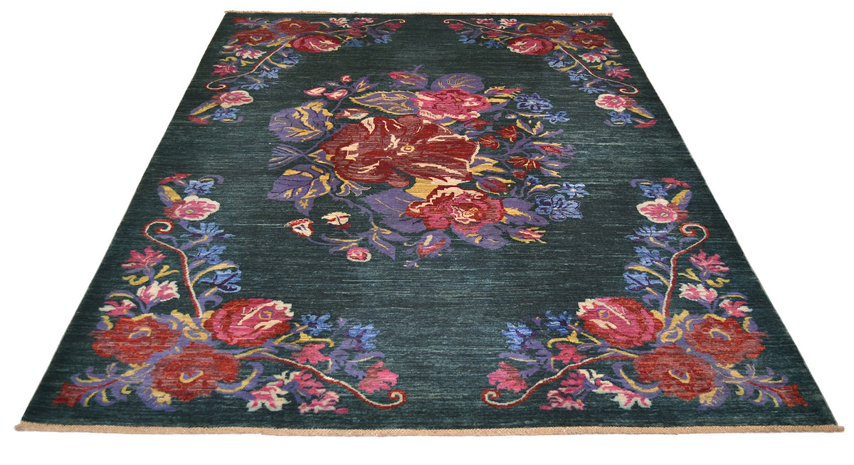 A rectangular Afghan floral area rug with a dark teal-green background and an ornate floral pattern in red, pink, purple, blue, and gold, shown from an overhead angle on a white background.
