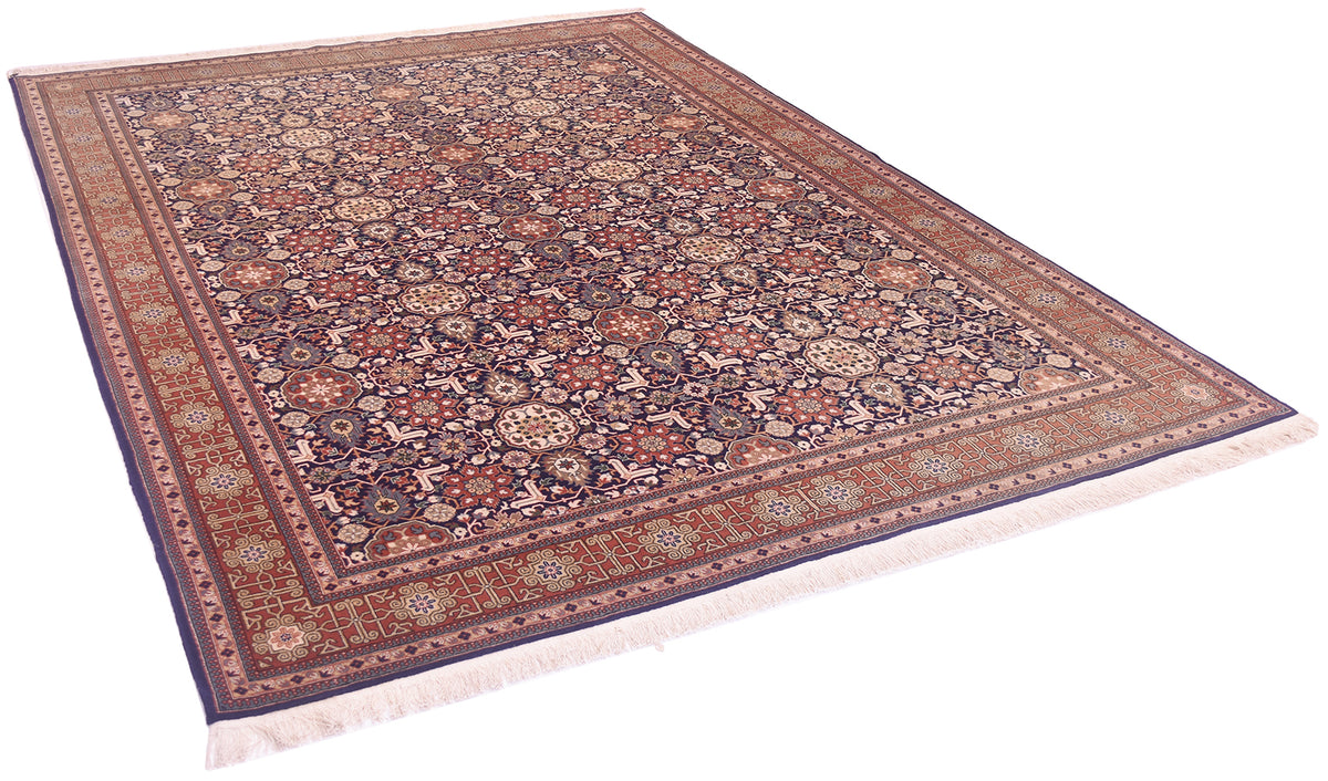 A traditional Turkish Hereke rug with an intricate floral pattern, featuring a dark navy blue field, reddish-brown borders, and cream fringe on a white background