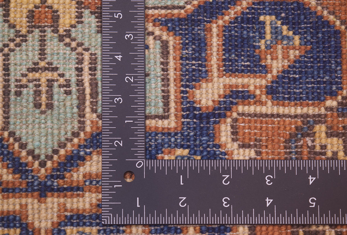 Close-up of the hand-knotted back of an Afghan Heriz 6x4 rug with a dark ruler placed over it to show scale, showing a blue, tan, and brown ornamental pattern.