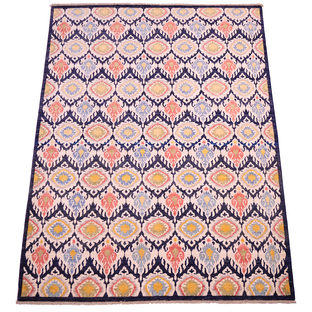 Overall view of Ikat design Carpet with cream, dark navy blue, terracotta coral, yellow gold, green as well as light blue. All over patterned design with pure wool pile.
