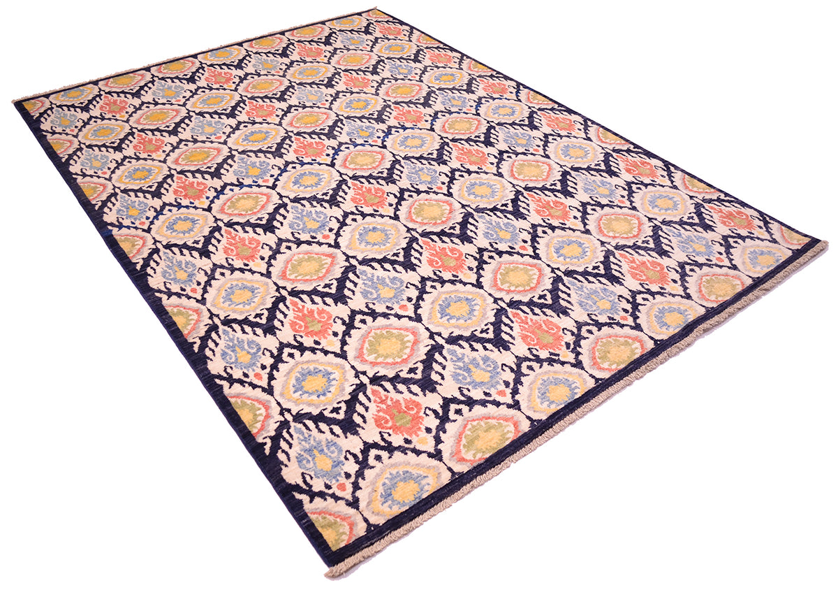 Angled view of handmade carpet from Afghanistan with all over design of ikat tetile patter with dark blue ground, cream, coral, green, gold yelloe and light blue. Cotton warp short fringe.