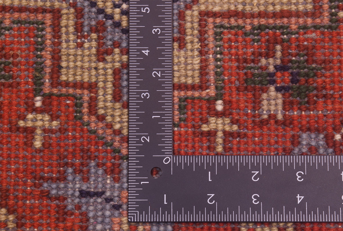 Close-up of the hand-knotted underside of Indo Heriz long runner with a dark ruler placed vertically and horizontally to show scale, featuring a red, beige, gray, and green geometric design.