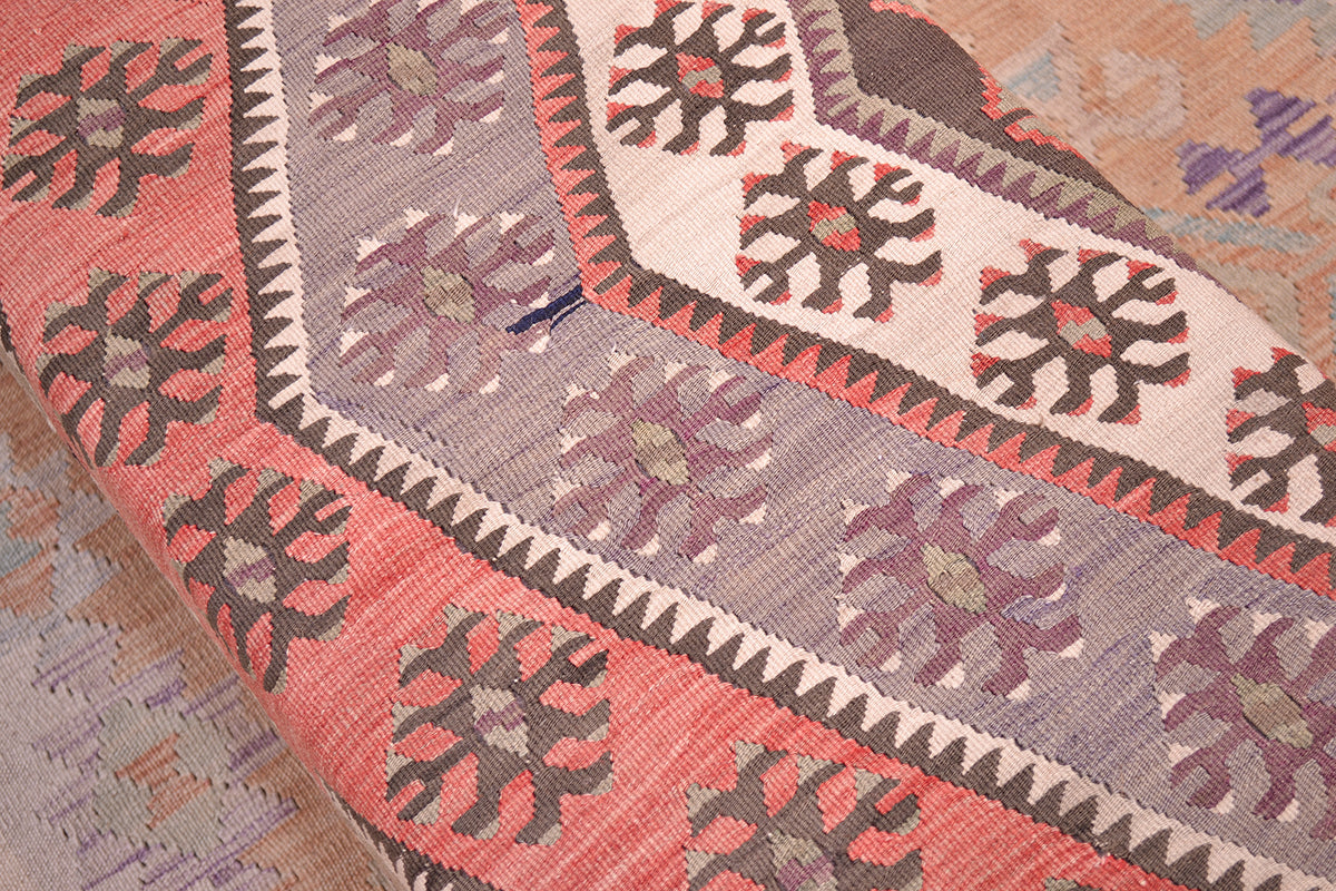 Detailed close up view of bench footstool with vintage turkish kilimmade from a central medallion from a large kilim with terracotta, cream, mauves, greys and chestnut browns. Handmade variations in colour a handmade kilim