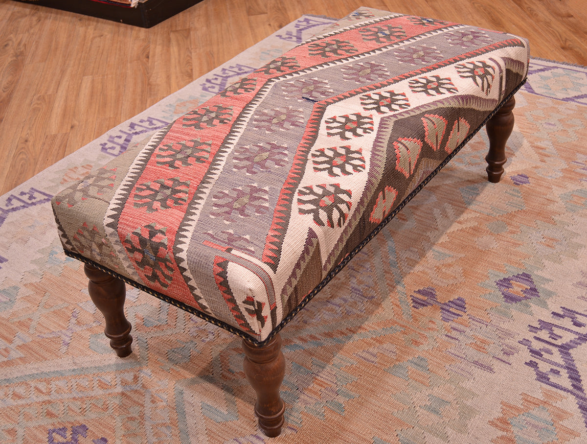 Kilim bench with vintage turkish kilim with soft colours resting on a soft wash afghan kilim. Kilim bench stool with grey-mauves, beige, terracotta, light greens and chestnut browns. Geometric tribal motifs.