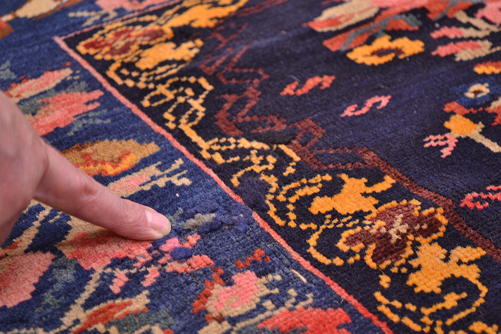 Detail of repiled area of antique rug in floral border with rose and flower gul farang design. Handknotted pure wool pile wovn on wool warps.