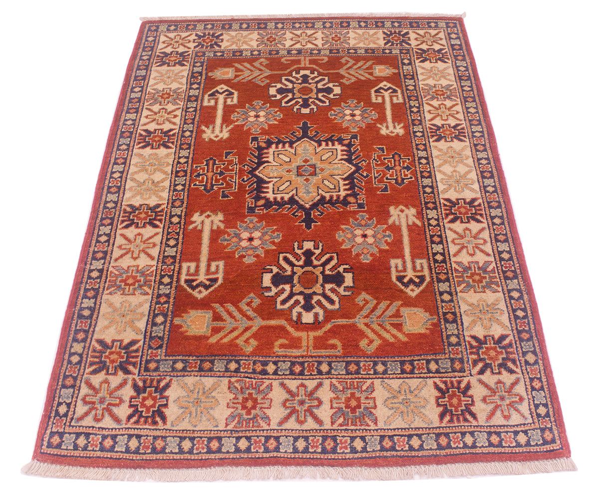 Handmade Kazak rug with rust-red field, dark-blue frame border, and orange geometric motifs