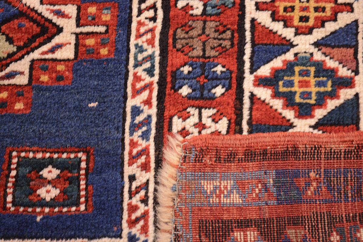 Reverse of Antique kazak rug showing pure wool warps fringe and colourful handknotted pile.