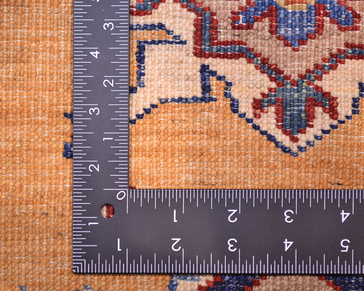 Close-up of the hand-knotted back of a Small handmade Fine Kazak Rug with a metal L-square ruler showing measurements in inches, highlighting the rug's knot density.