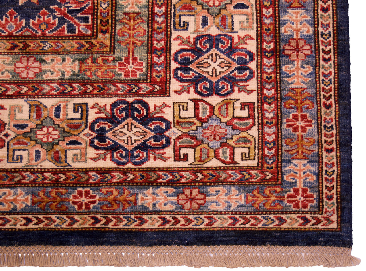 Lower border close-up of navy kazak rug with red, blue, and cream trims