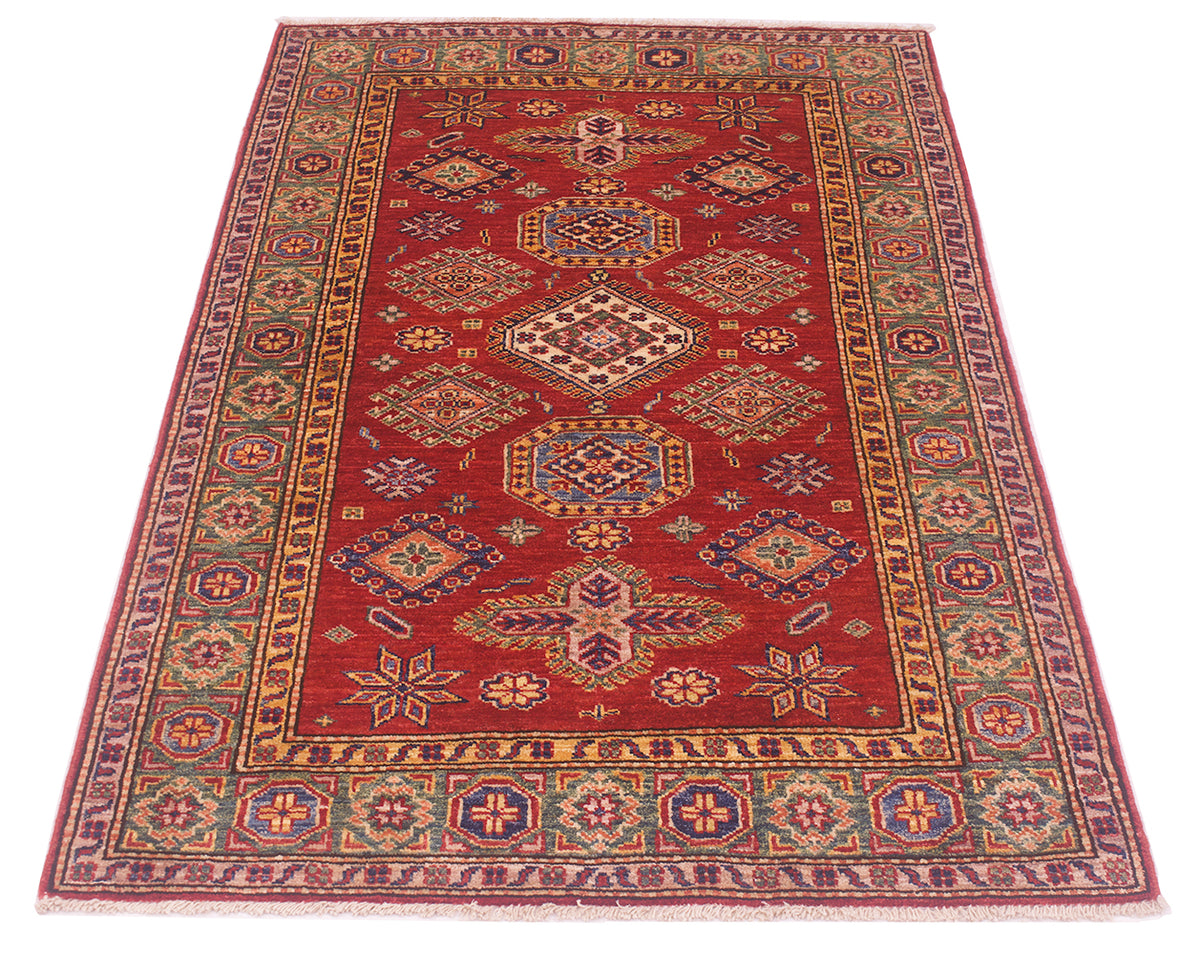 A traditional rectangular fine Afghan Kazak area rug with a deep red field, featuring a central medallion pattern and an ornate multi-colored border in blue, gold, and beige tones, shown flat against a white background.