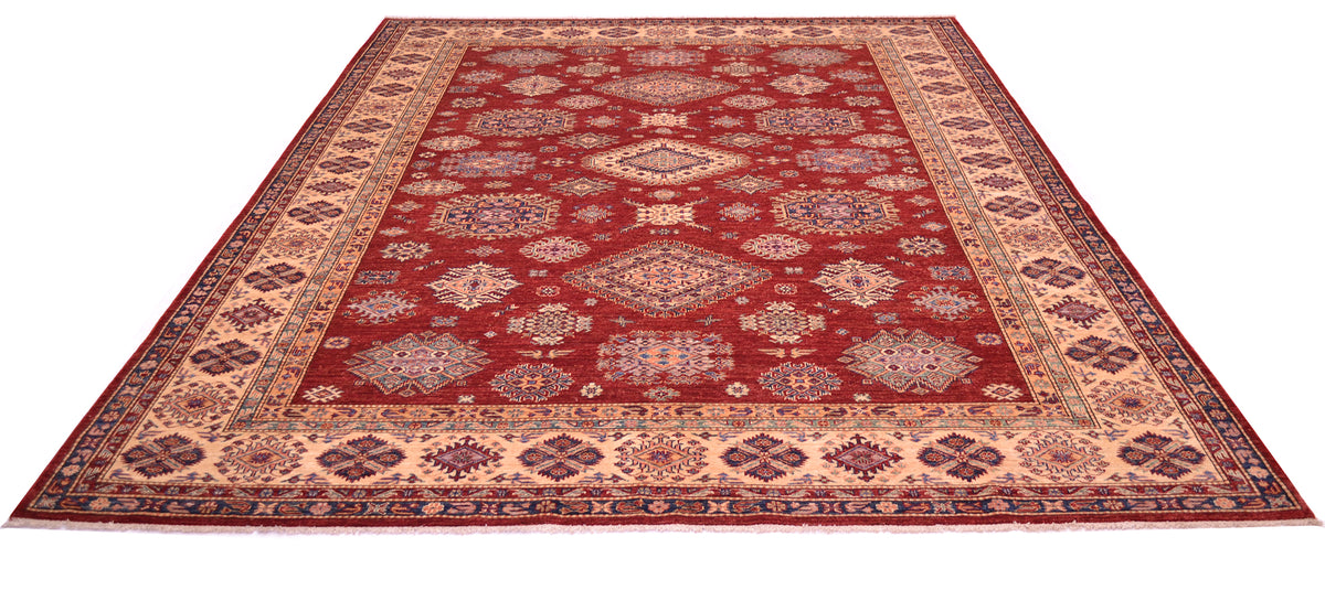 A traditional 12x9 Large handmade red fine Kazak carpet with a deep red field, beige and navy blue geometric borders, and a central medallion pattern, shown from an elevated perspective against a white background.