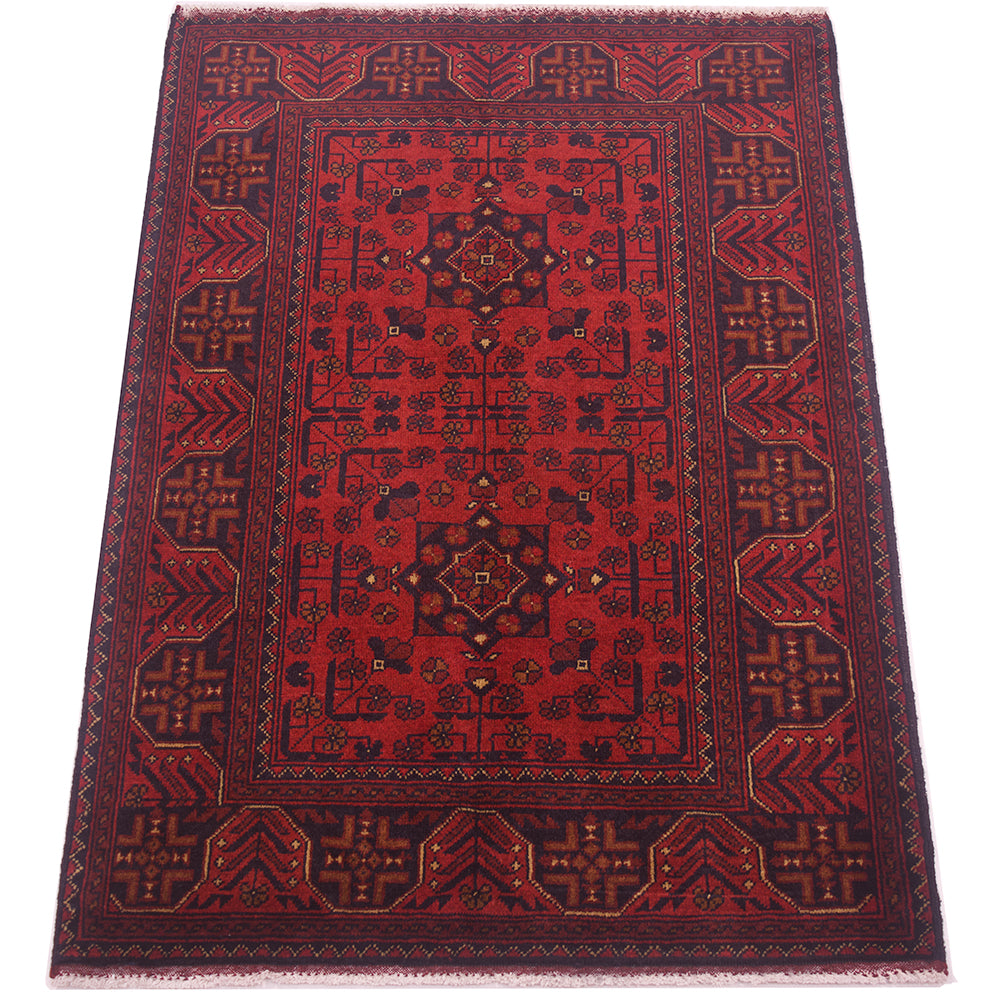 A traditional anfghan area rug with a deep red field, dark navy blue borders, and intricate geometric and floral motifs in gold and beige.