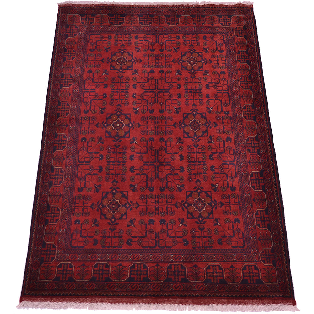 A rectangular red afghan area rug with a dark navy blue geometric and floral pattern, featuring a decorative border and fringed edges on a white background.