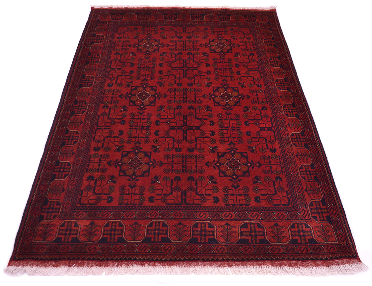 A rectangular red afghan rug with a dark navy blue geometric pattern and border, shown flat against a white background.