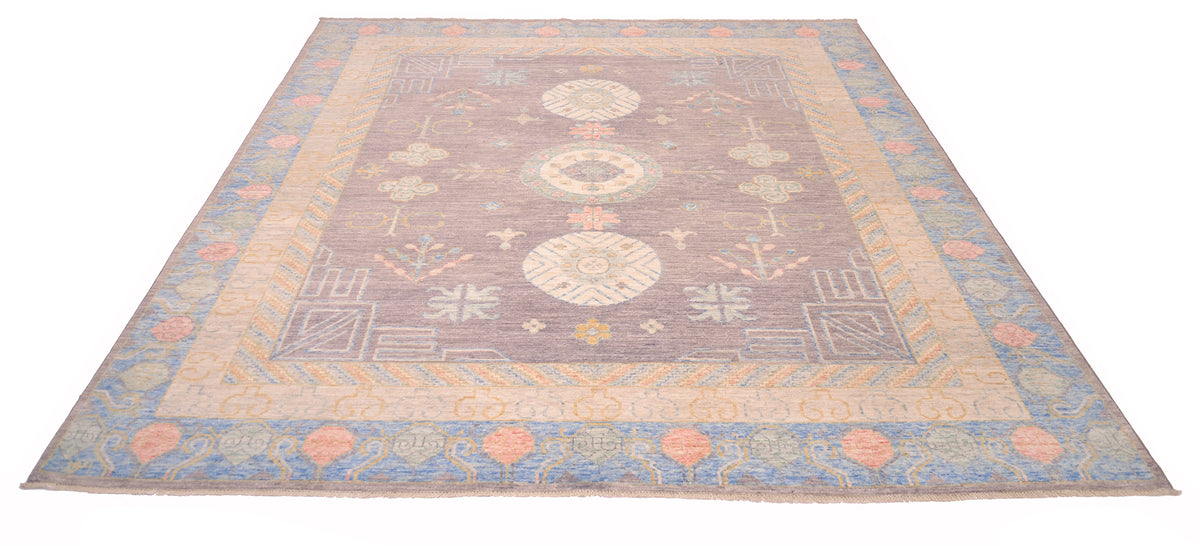 Over all view of pastel toned Khotan carpet handknotted in Afghanistan with natural vegetable dyes and handspun wool. Traditional antique Khotan design with three medallion moon guls. Powder blue border with light green and coral pink motifs.