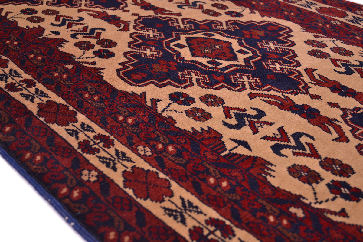 A close-up of a traditional patterned runner rug with a beige field, dark red floral motifs, and navy blue medallion