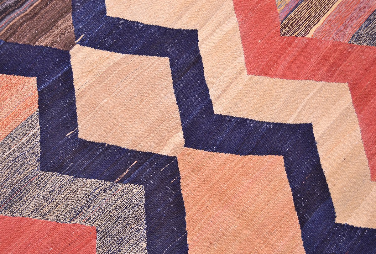 Close-up of kilim rug weave with navy, red, and cream geometric blocks