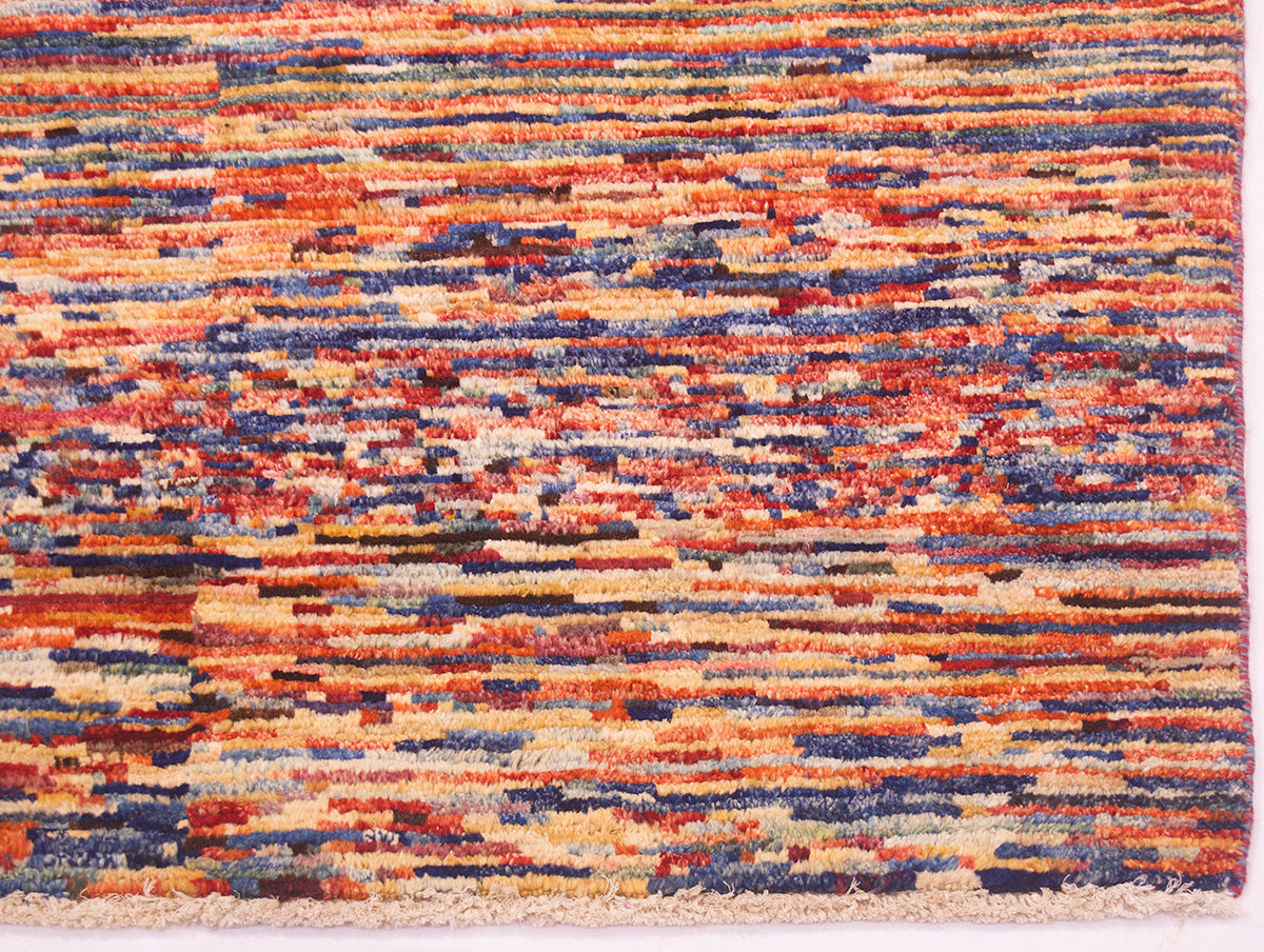 A close-up of a textured handwoven modern Afghan Gabbeh rug with a multicolour abstract pattern of horizontal stripes in orange, red, blue, beige, and brown.