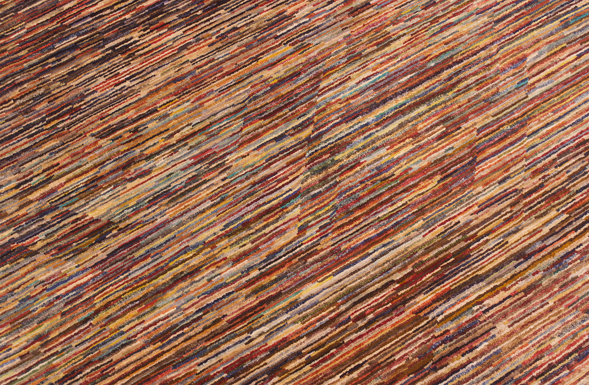 A close-up of Handmade modern Afghan Gabbeh carpet featuring diagonal stripes in a multicolour pattern of rust red, brown, beige, and muted blue.