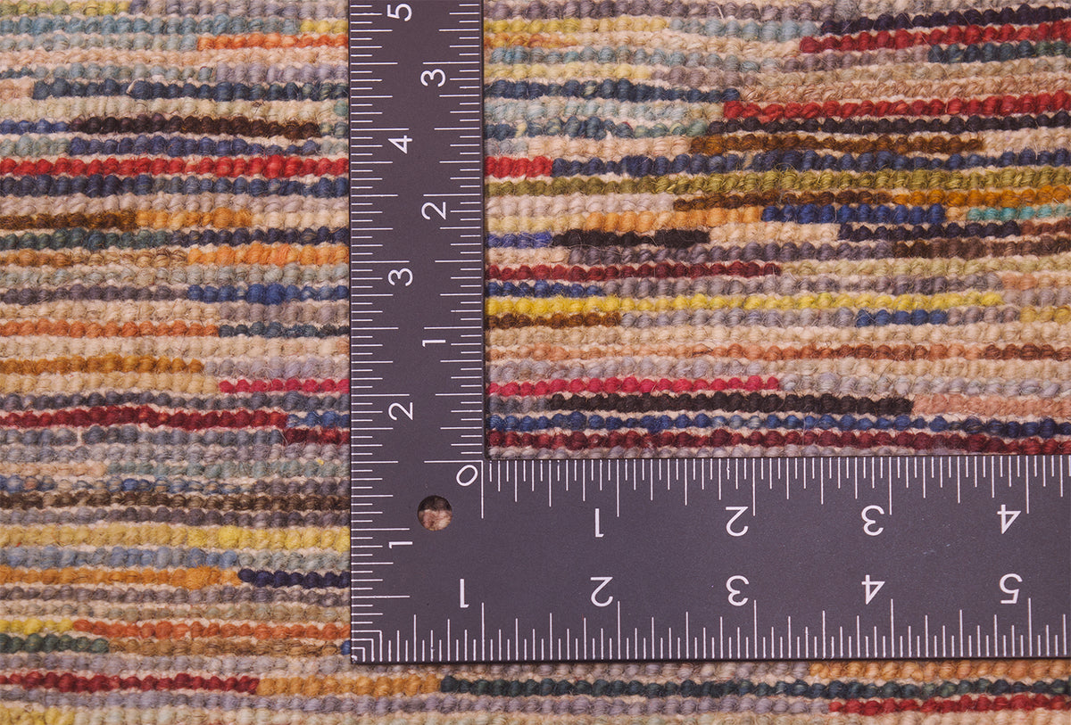 Close-up of the hand-knotted weave of a handmade modern Afghan Gabbeh carpet with a multicolour abstract pattern, shown with a metal L-square ruler to indicate scale of the knot density.