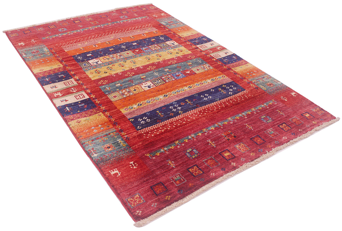 A rectangular hand-knotted colourful Loribaft rug with a complex geometric design, featuring horizontal bands of red, orange, blue, and beige with traditional tribal patterns, shown on a plain white background.