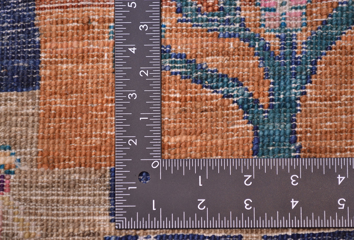 Loribaft carpet weave close-up with measurement ruler over orange and blue patchwork