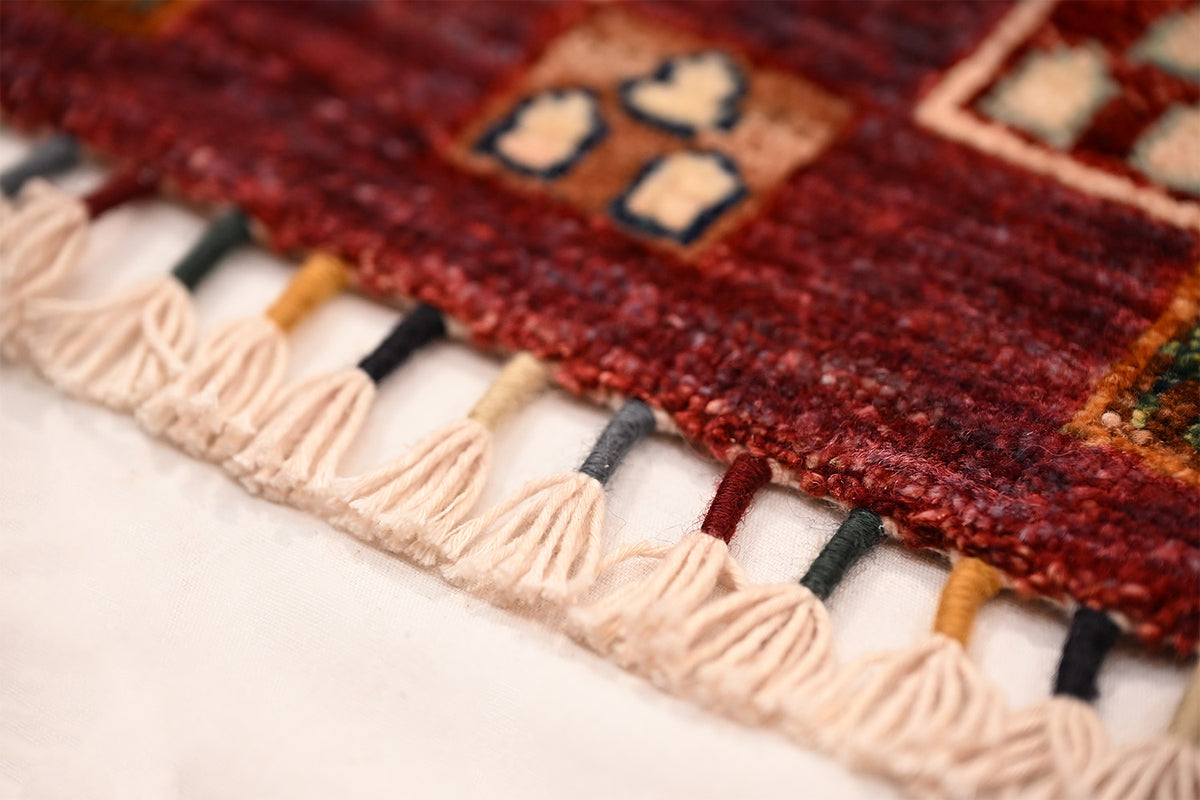 Handmade Loribaft Gabbeh rug fringe detail, off-white tassels along the bottom edge