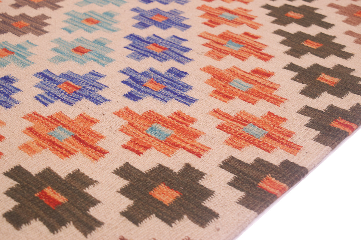 A close-up of a woven kilim corridor runner with a geometric pattern in orange, blue, brown, and beige, photographed on a white background.