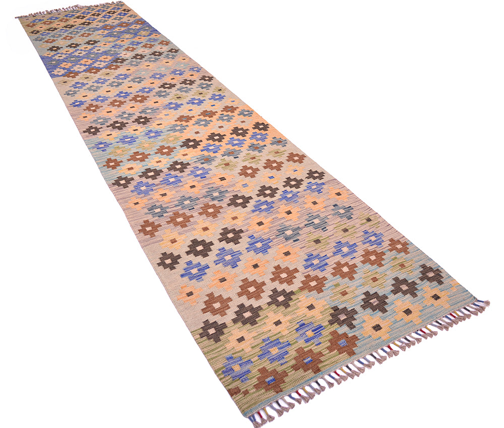 A 13ft long rectangular woven multicolour long Kilim runner rug with a geometric floral pattern in beige, brown, blue, and orange, finished with fringed ends, shown on a plain white background.