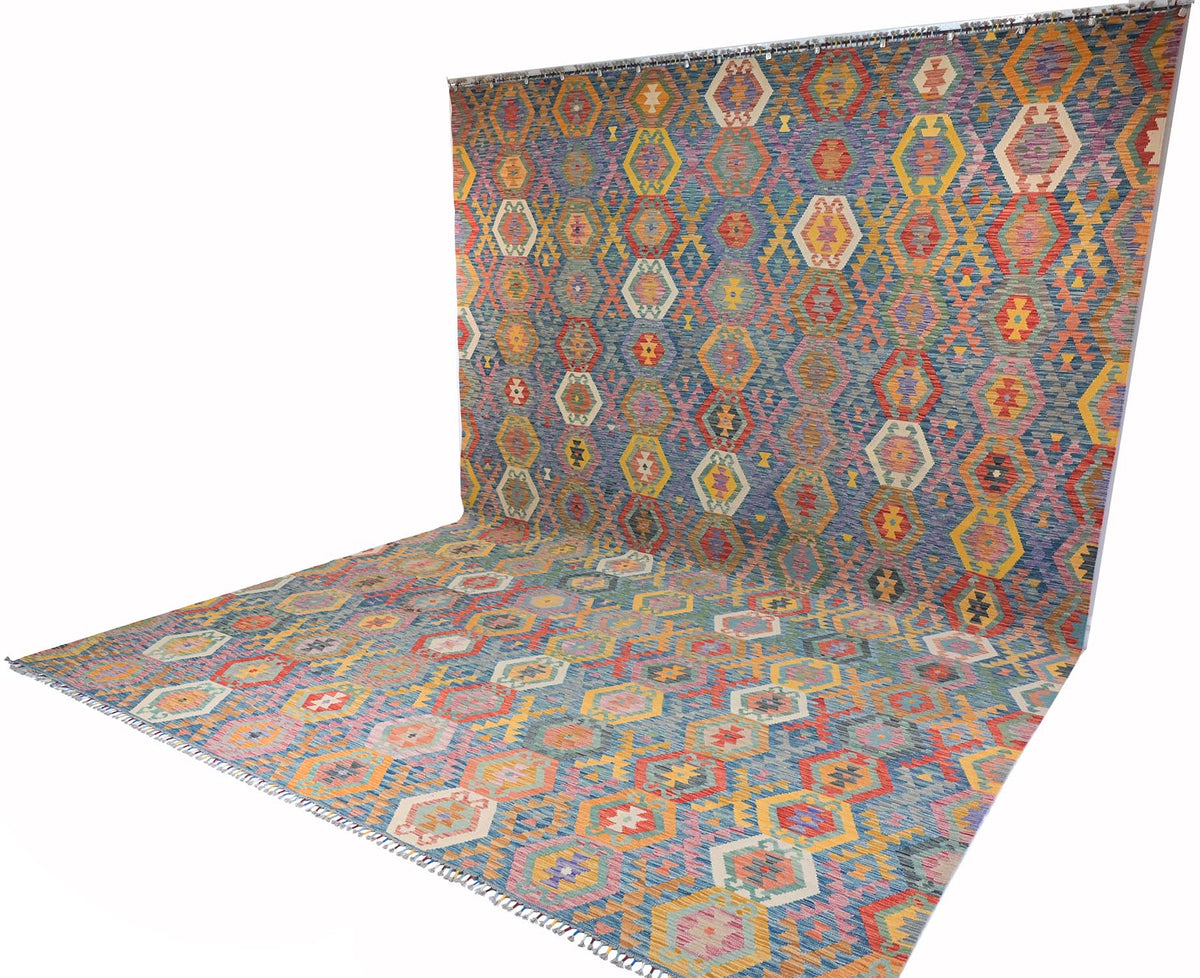 A Giant Handwoven Afghan Kilim rug with a geometric pattern, shown draped to display both its flat surface and its hanging wall form against a plain white background.