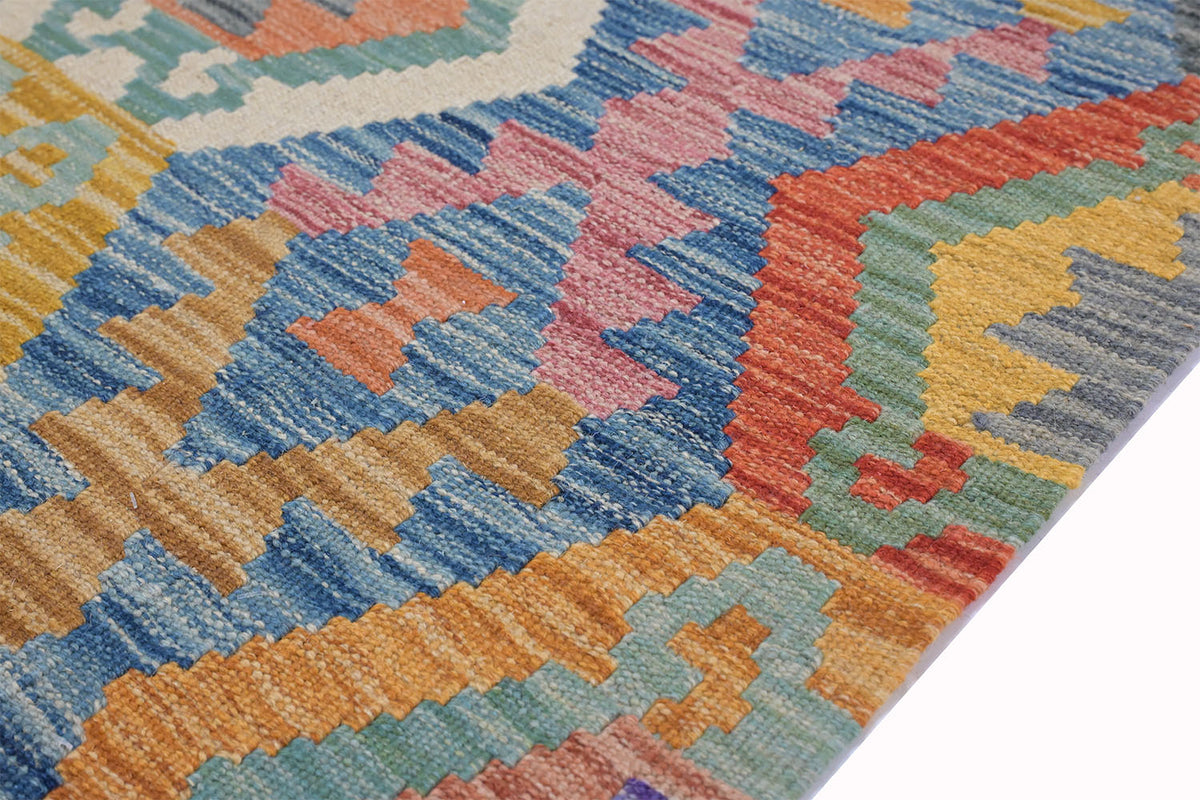 A close-up of a colorful geometric Giant Handwoven Afghan Kilim rug patterned with woven texture, featuring shades of blue, orange, pink, yellow, and green.