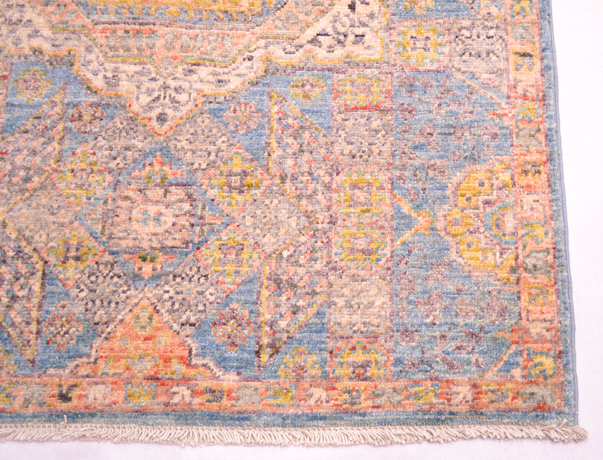 Corner of handkotted runner showing cotton fringes and geometric border and field decorative devices