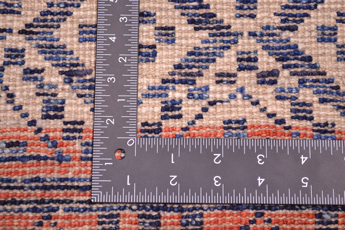 Back of Afghan carpet showing handknotting in cream, blue and amber-red.