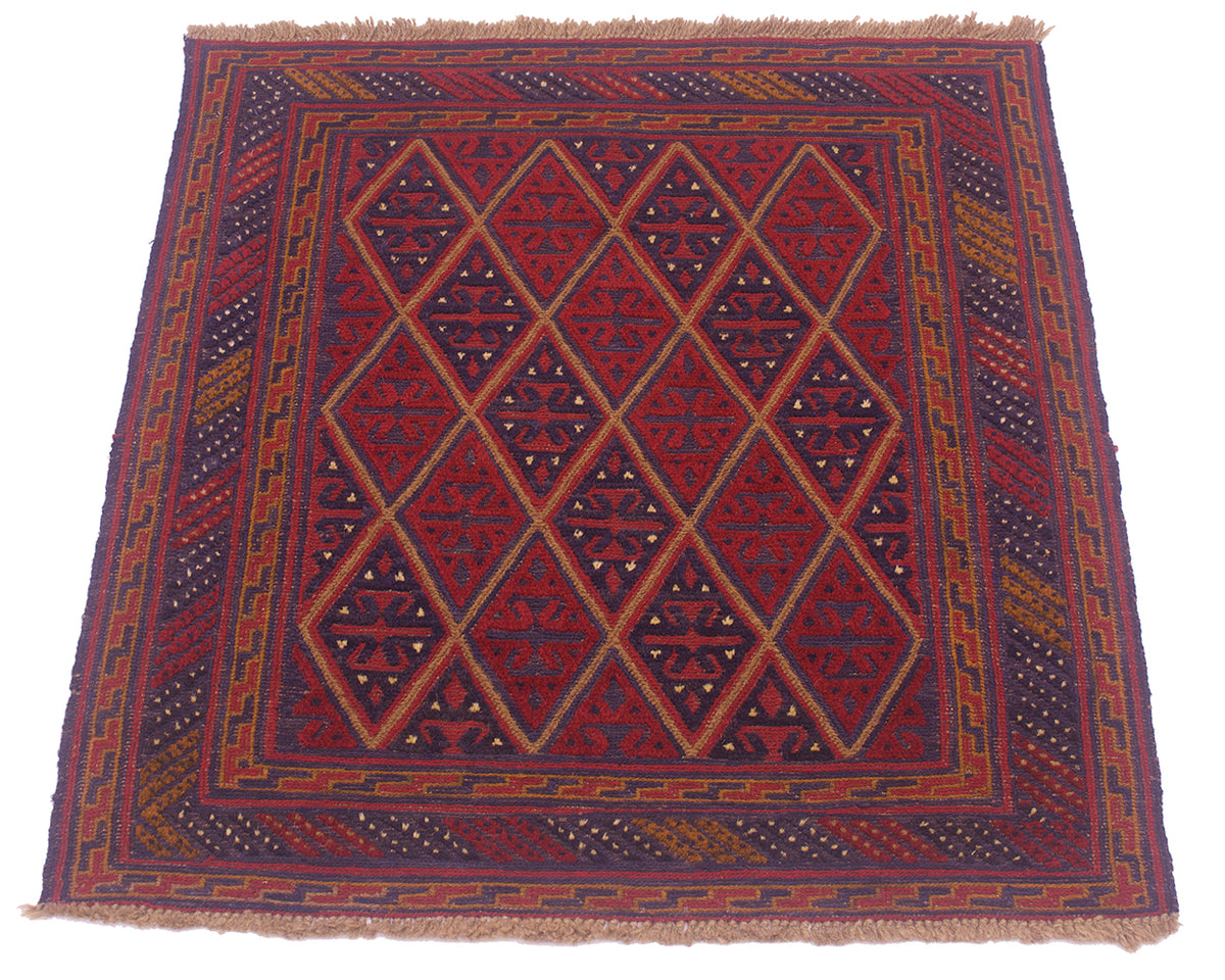 A square woven Mushwani Afghan rug with a geometric diamond pattern in red, navy blue, and orange, featuring a fringed top and bottom edge, shown against a plain white background.