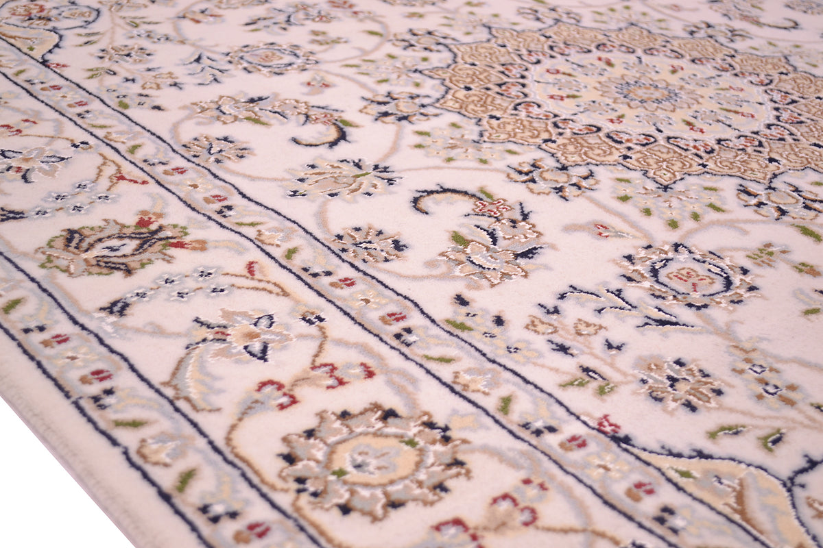 A close-up view of an ornate handmade Indo Nain rug with a cream-coloured field, detailed floral motifs, and a navy blue border.