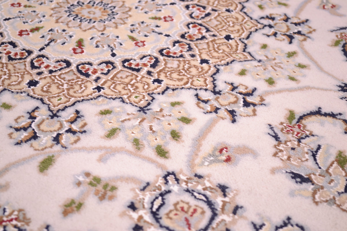 Close-up of an ornate Indo Persian Nain rug with a cream background and intricate floral motifs in beige, navy blue, green, and red.